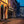 Derry street at blue hour with golden light on doors and closed shutters.