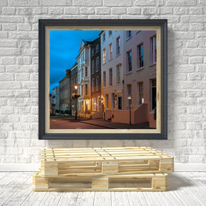 Quiet Derry street with receding townhouses and pools of golden doorway light.