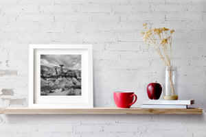 Broad capstone and folded desert rock in a monochrome landscape photograph.