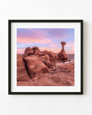Red desert hoodoos beneath a pink and lavender sunset sky, colour landscape photograph.