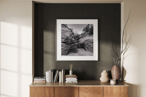 Curved stone surfaces framing a sandy gap beneath a pale sky.