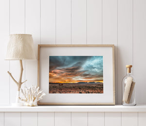 serene desert view under bright orange sunset clouds