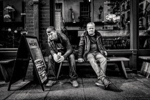 Dublin street portrait with two seated people beside a cafe window