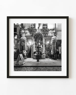 Dublin pub frontage with flower baskets and people in black and white