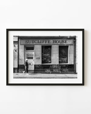 Woman passing Sutcliffe House in Dublin in black and white