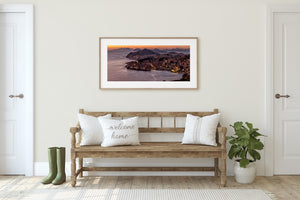 Dubrovnik coastal cityscape at sunset with orange sky and distant hills