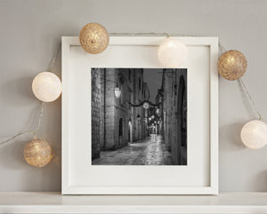 Dubrovnik lane with festive decorations above patterned stone paving