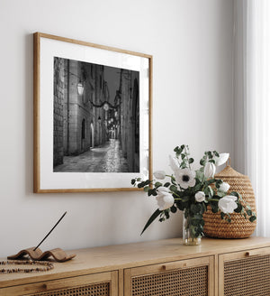 Monochrome evening photograph of a lantern-lit Dubrovnik alley