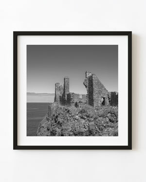 Dunluce Castle ruins above the sea in black and white