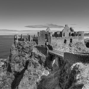 Black and white Dunluce Castle on a rocky Northern Ireland coastal cliff