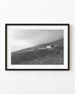 White house on a misty Dunmore Head hillside in black and white