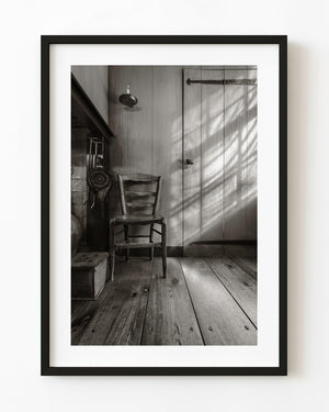 Wooden chair and diagonal window light in a Dutch farmhouse interior