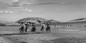 Kazakh horsemen riding with eagles in Gobi Desert