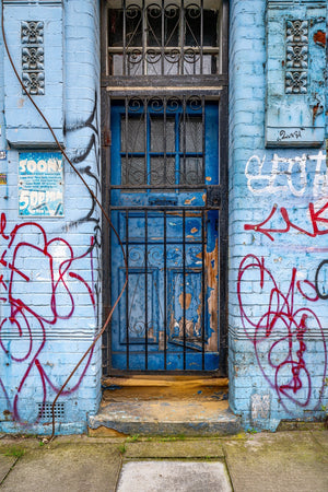 Blue doorway and graffiti on a worn East London facade