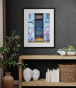 Urban colour and peeling surfaces around a graffiti-covered blue door