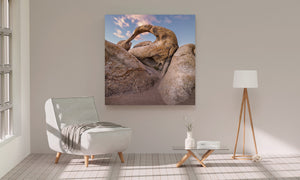 Blue sky and soft clouds seen through a rounded rock arch