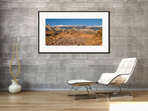 Sunlit boulders and desert scrub beneath a distant mountain range