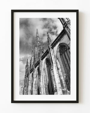Edinburgh Tolbooth Church spire and Gothic windows beneath textured clouds in black and white