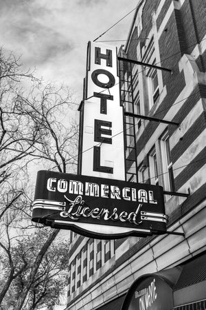 Vertical HOTEL lettering and Commercial Licensed sign against a cloudy Edmonton sky