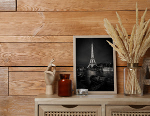 Black and white view across the Seine toward the illuminated Eiffel Tower