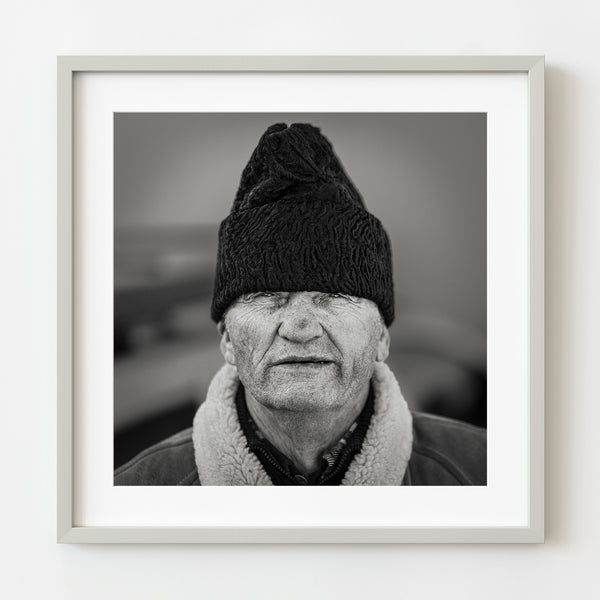 Black and white portrait of elder Romanian man in winter hat