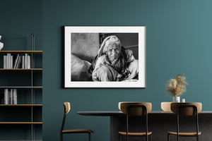 Monochrome portrait of an older Indian woman wrapped in a head cloth.