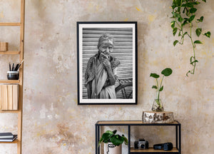 Older Indian woman in a patterned shawl with a bicycle at the edge of the photograph.