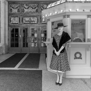 Black and white portrait of an elegantly dressed woman inside the Elgin Theatre in Toronto.