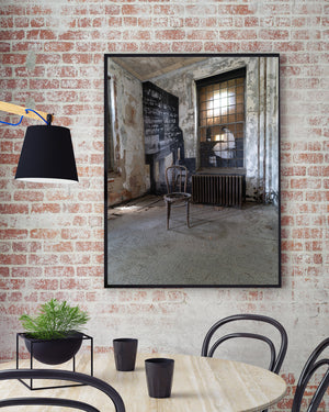 Daylight enters an abandoned Ellis Island hospital room through a tall window.