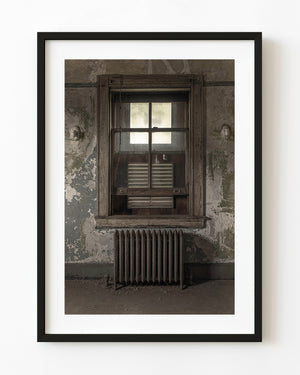 A tall window above an old radiator inside the abandoned Ellis Island Hospital.