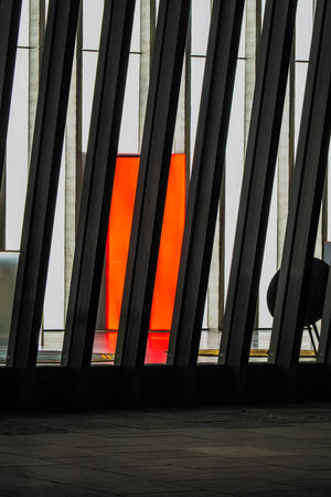 Diagonal structural beams with red illuminated panel London