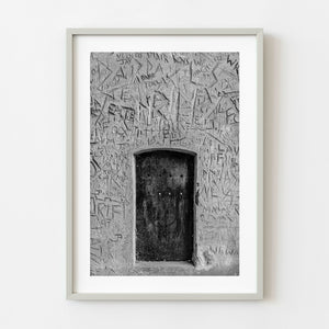 Black and white medieval wooden door set in carved plaster wall England