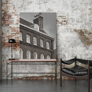 A vertical photograph of an English house’s windows and chimney in black and white.