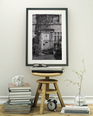 Stonework, climbing ivy and iron railings surround an English house entrance.