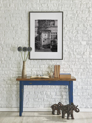Sunlight falls across a gated doorway in a historic English house.