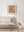 Colour photograph of an exposed pipe on a peeling orange wall in Europe.
