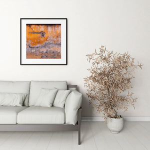 Architectural detail of weathered orange plaster and exposed metal piping.