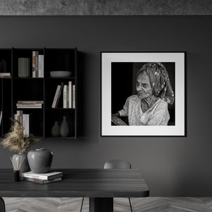 An Indian woman’s profile and patterned headscarf emerge from a dark background.