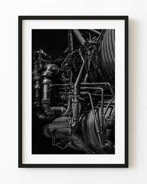 Black and white close-up of curved pipes and connections on an F1 rocket engine.