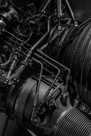 Monochrome close-up of dense tubing and curved metal on an F1 rocket engine.
