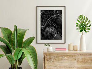 Rocket engine pipes cross ribbed metal housings in a dark industrial photograph.