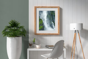 Vertical waterfall framed by rugged rock and mist