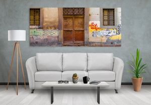 Colourful markings and peeling wall textures frame an old Florence entrance.