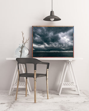 A bright opening contrasts with dark blue-grey clouds off the Florida coast.