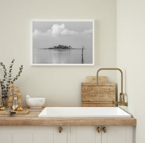 Black and white Florida Gulf Coast view with a palm island, calm water and a navigation marker.