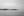 A quiet monochrome Gulf Coast scene with utility poles, low islands and pale morning sky.
