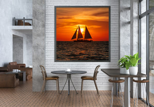 Florida sunset reflected across ocean waves and sailboat