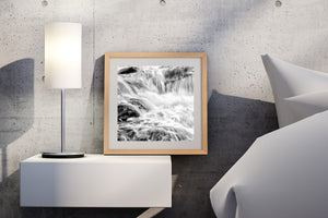 Cascading water forms soft flowing lines against sharply textured rocks.