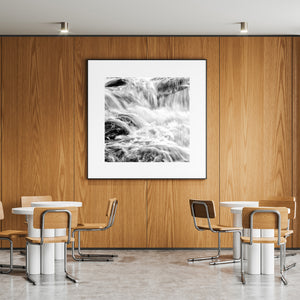 White foam and dark stone create contrasting patterns in a close waterfall photograph.