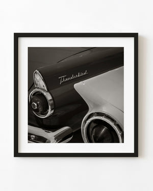 Chrome tail lights and sculpted tail fins of classic Ford Thunderbirds photographed in black and white.
